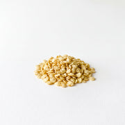 A pile of small, light-colored grains or seeds is the main focus of the image, which is set against a plain white background.