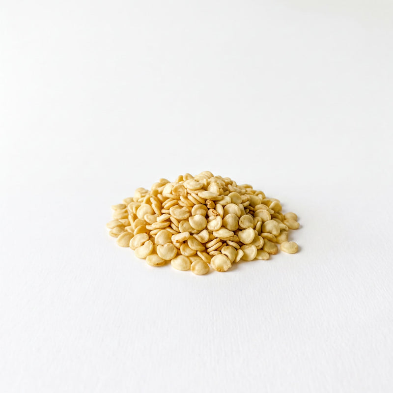 A pile of small, light-colored grains or seeds is the main focus of the image, which is set against a plain white background.