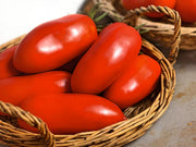 A wicker basket filled with bright red tomatoes.