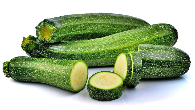 a group of zucchini cut in half on a white surface
