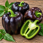 Midnight Dream sweet bell peppers close-up showing glossy deep purple-black fruits with one sliced open revealing bright crisp green flesh on a rustic wood surface